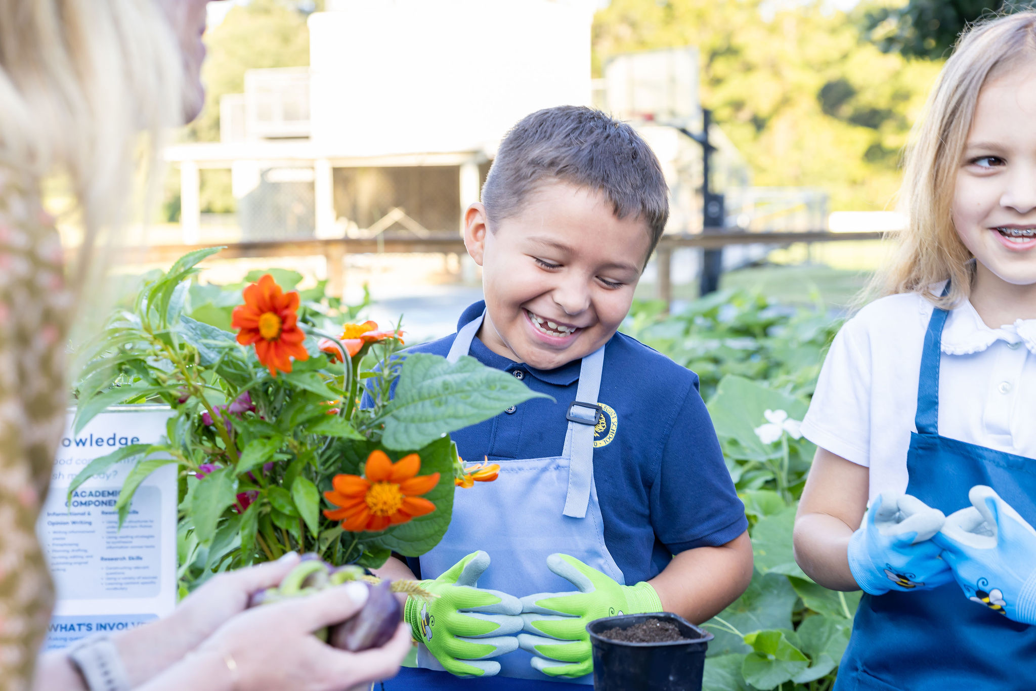 A smiling young student working in the on campus garden.