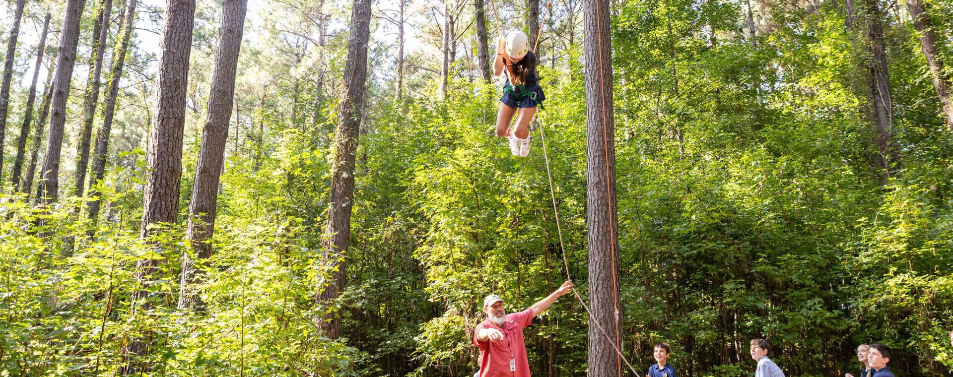 A middle school student participating in the ropes course on campus.