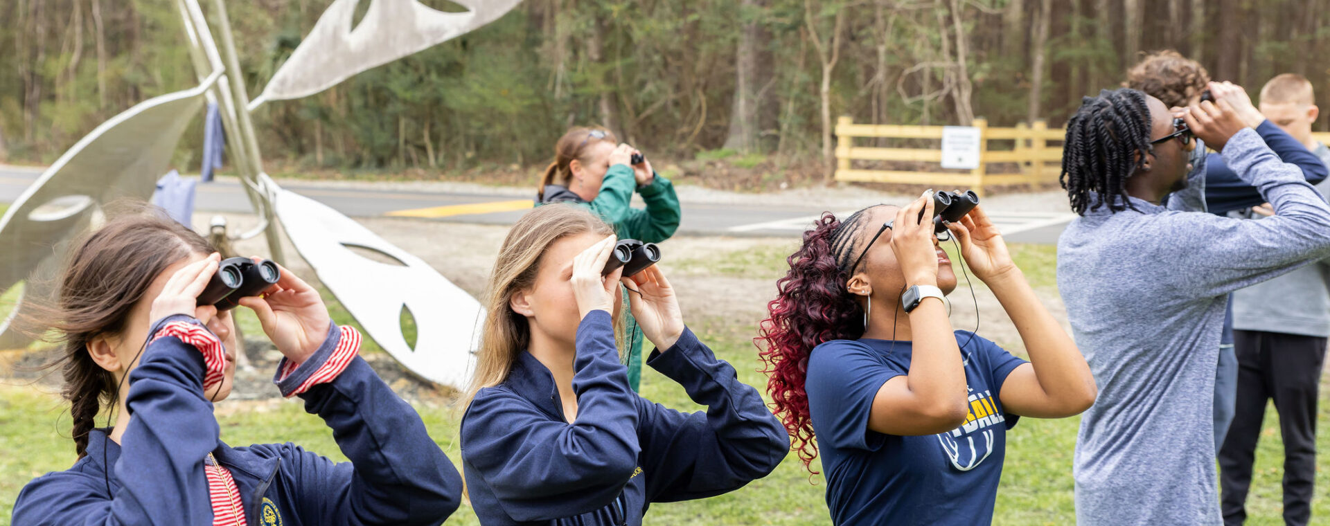 Students identifying birds with binoculars during zoology. 