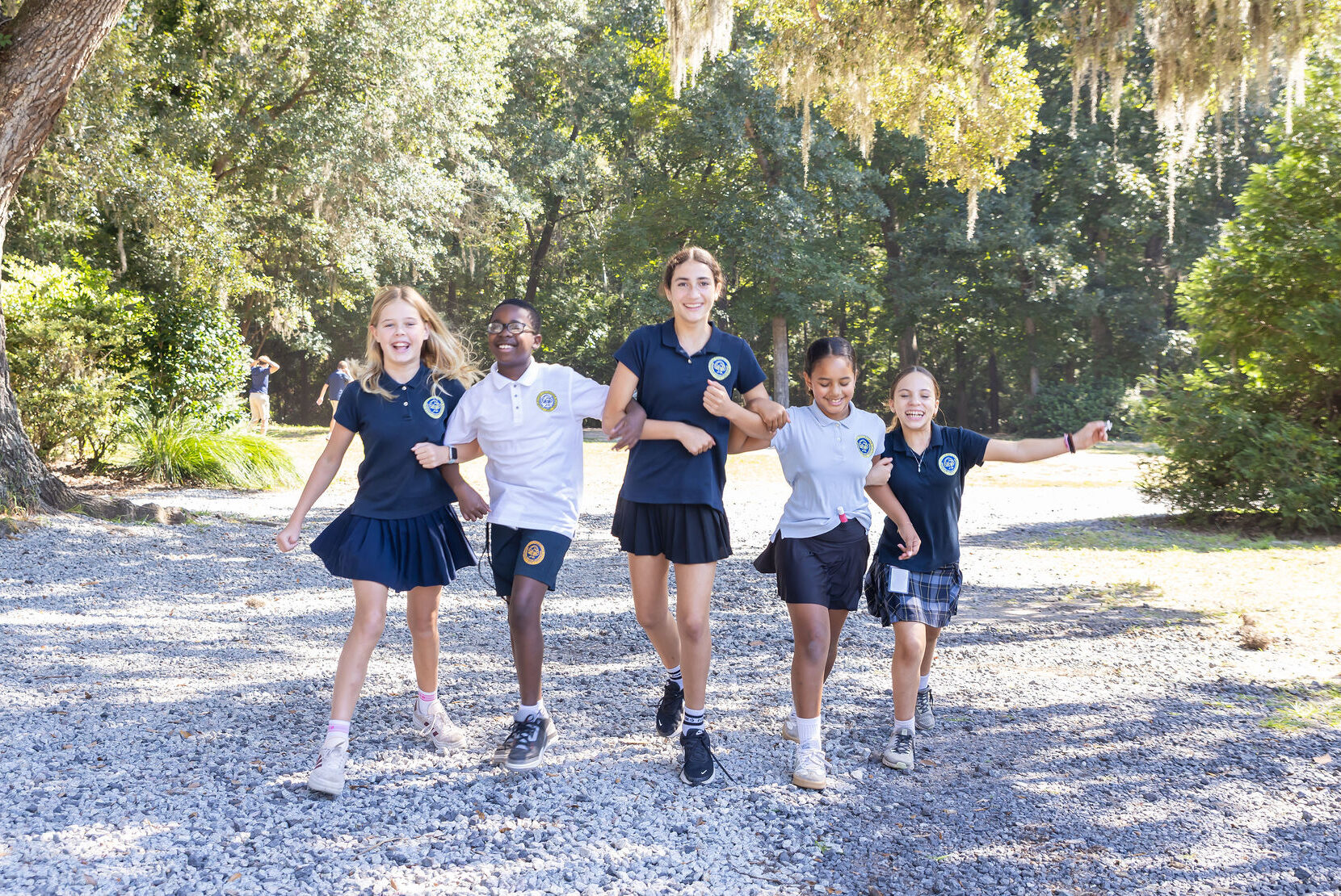 CCS students arm in arm smiling while walking on campus.