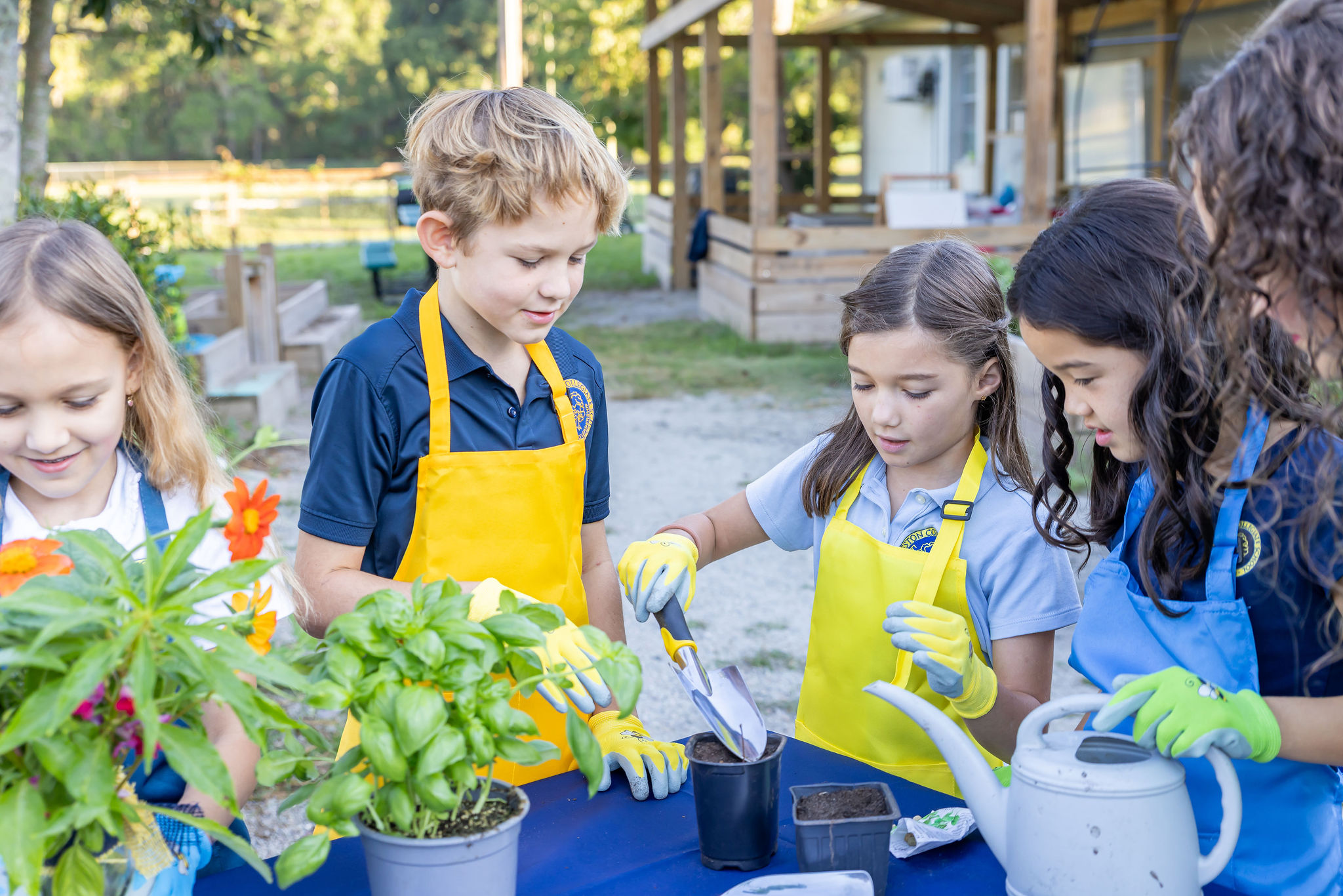 A group of young students working with plants and potting soil.