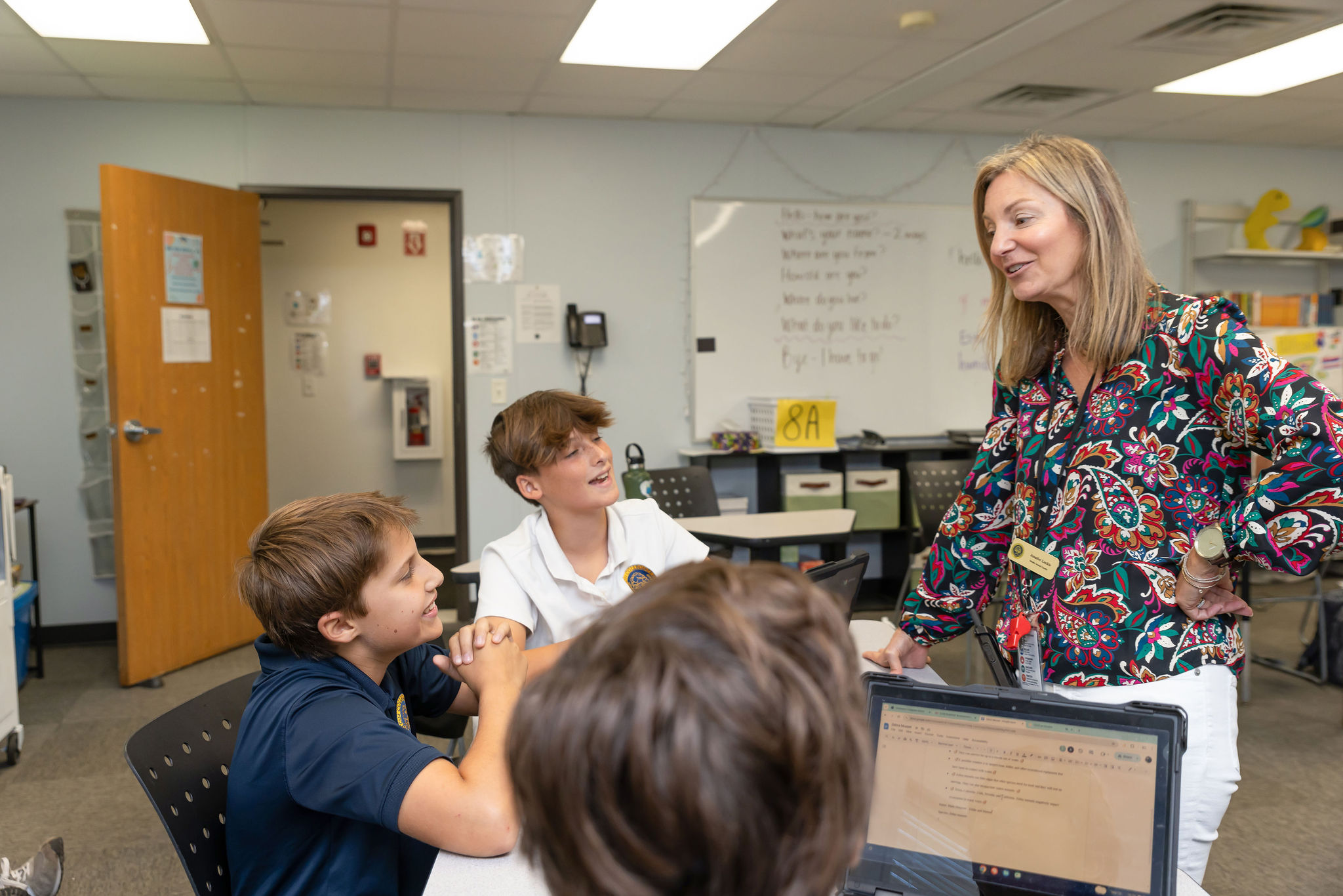 A CCS teacher interacting with a small group of students.