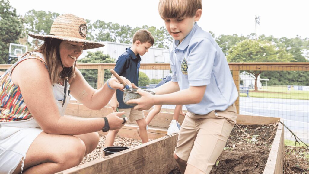 A teacher and young students working in the garden.