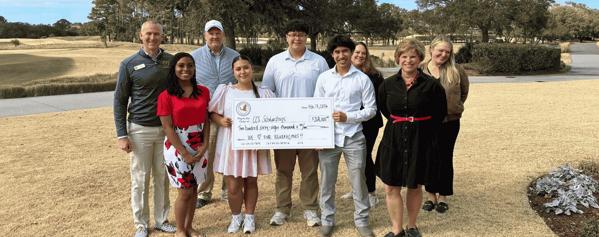 Students and adults with a presented check during the McNair Invitational at Briars Creek golf course.