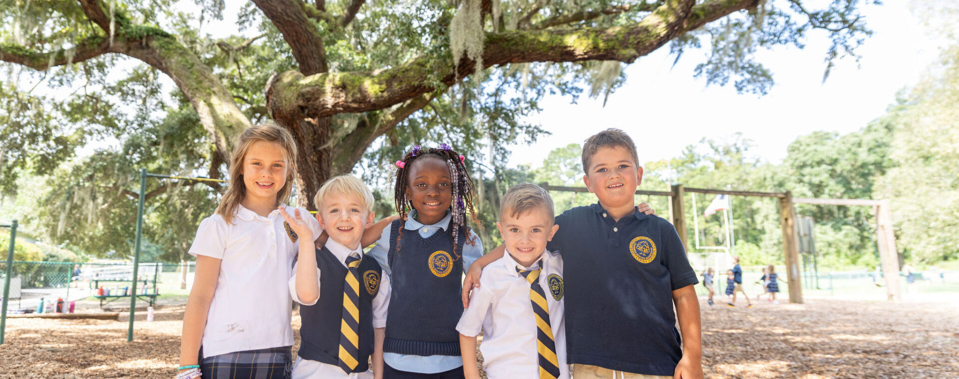 Lower school students smiling on the playground.